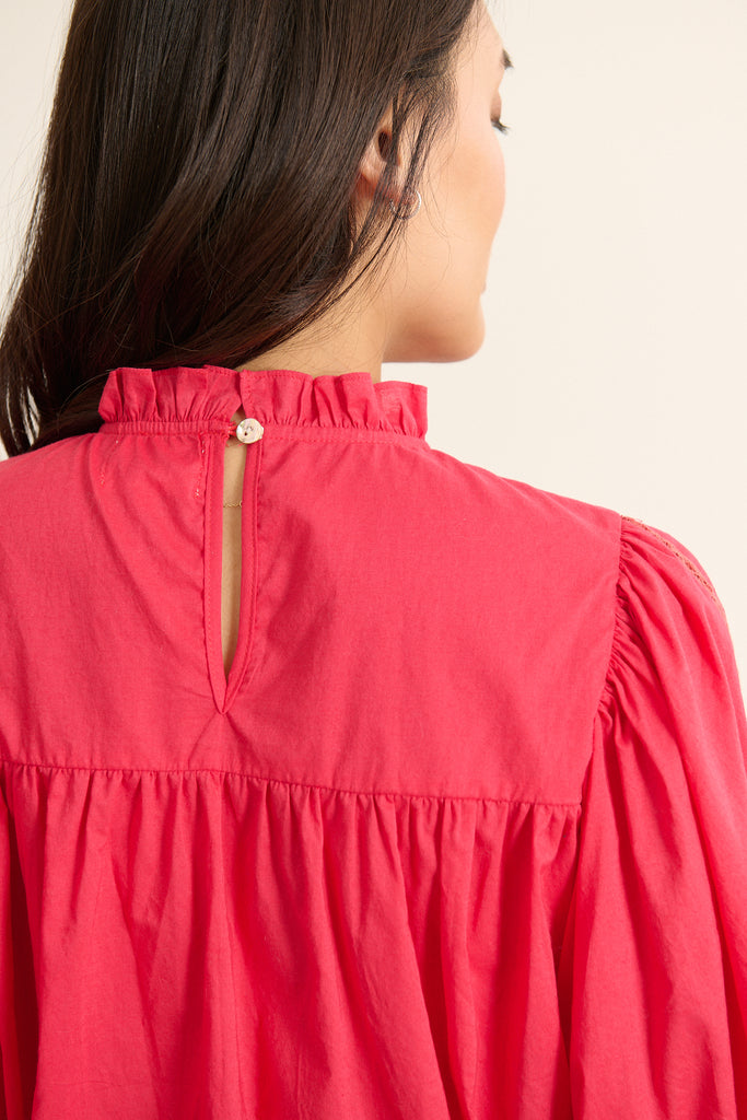 Vue arrière de la blouse ample, volume souple avec fronces sous l'empiècement et finition arrondie en bas.