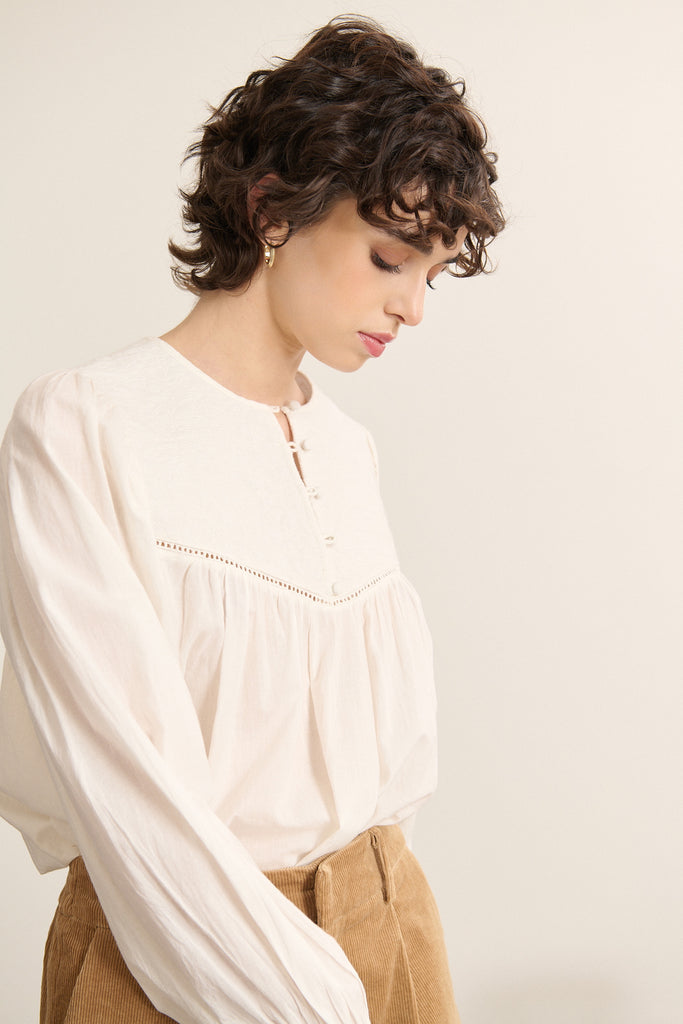 BERRY, la blouse au col rond dégagé avec finitions nettes, doublé d'un biais ton sur ton cousu à plat pour maintien discret.