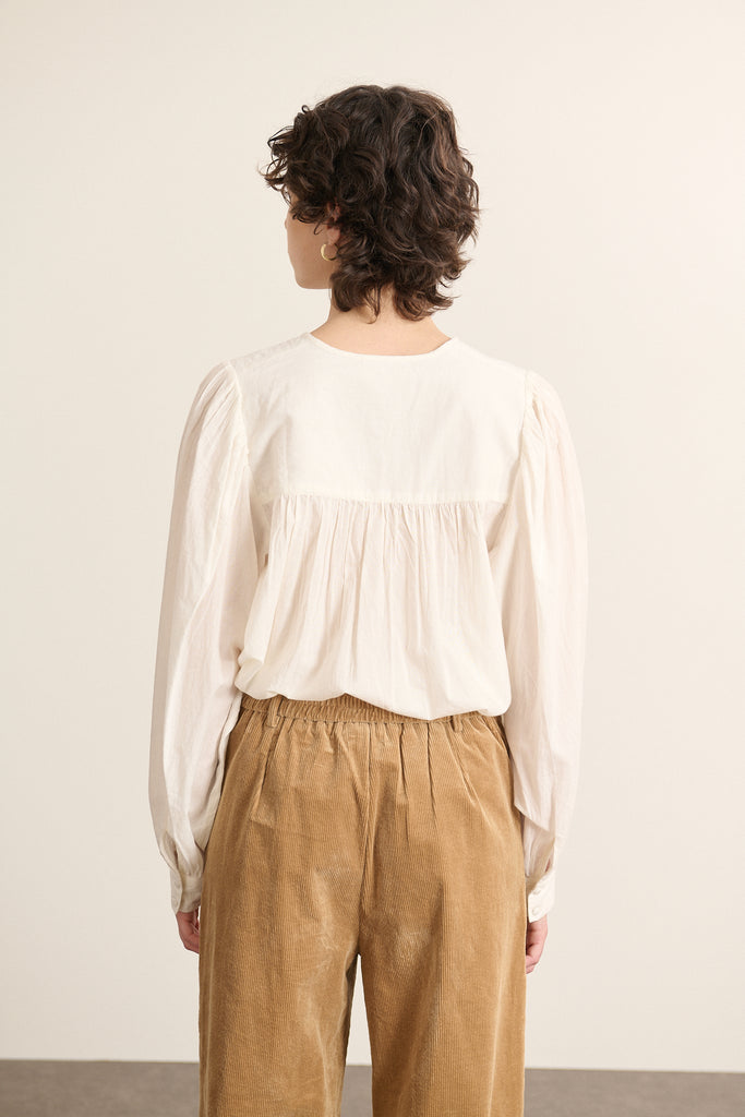Vue arrière de la blouse en voile de coton, coupe droite avec empiècement haut et base légèrement arrondie.