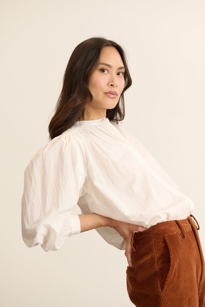 Vue arrière de la blouse ample, empiècement haut matelassé et base légèrement arrondie avec fronces légères.