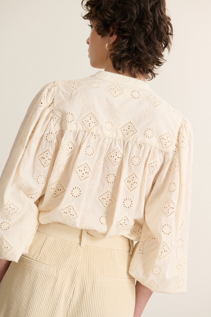 Vue arrière de la blouse écru, coupe évasée avec jeu de fronces régulières apportant un tombé souple dans le dos. 