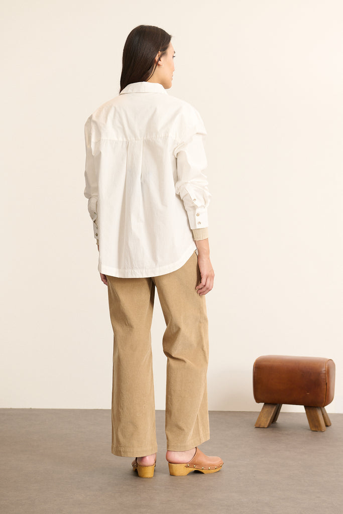 Vue arrière de la chemise ample, découpe horizontale haute avec fronces légères pour créer du volume au dos. 