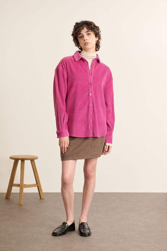 Mannequin femme de face portant une chemise en velours rose, coupe droite avec col classique et patte de boutonnage visible. 