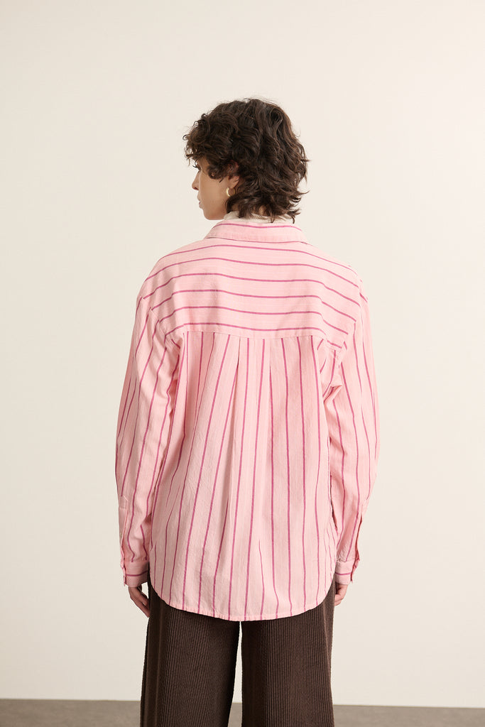 Vue arrière de la chemise ample rose, découpe haute dans le dos avec fronces réparties pour plus d'aisance. 