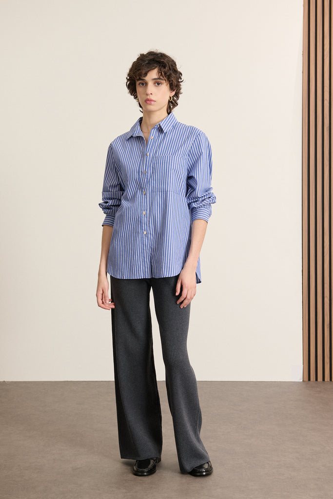 Mannequin de face portant une chemise bleu à rayure, coupe ajustée mais confortable, col classique et poches poitrine.
