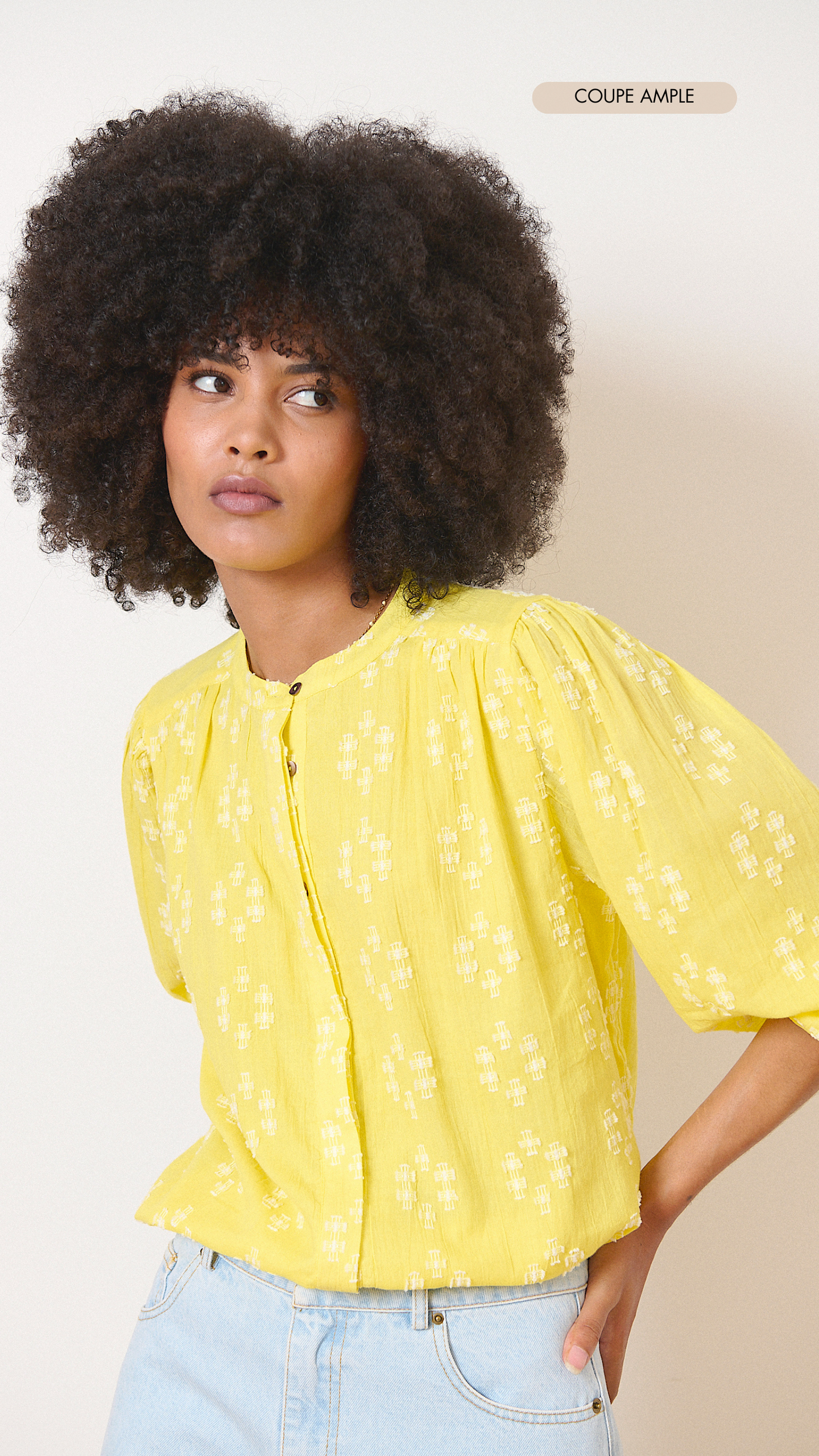 Blouse jaune en broderie plumetis avec manches larges boutonnées et découpes et fronces élégantes collection printemps été