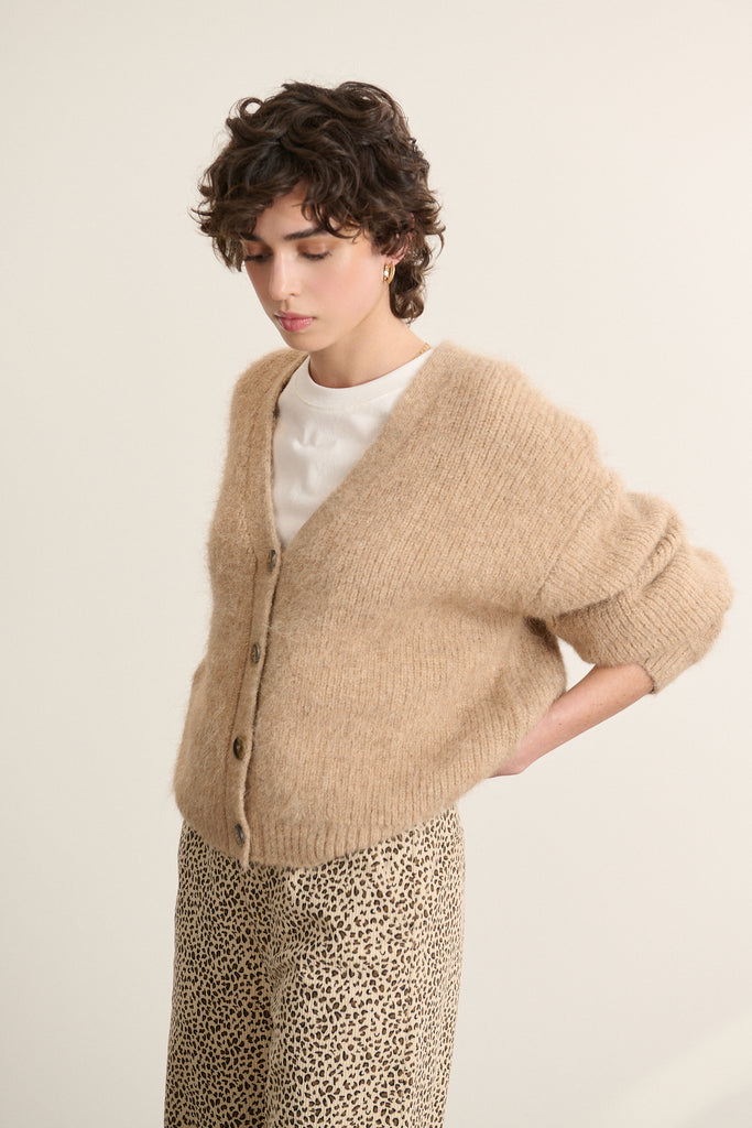 Pull avec fermeture par boutons effet corne placés sur le devant, reflets mats et espacement régulier sur la patte.