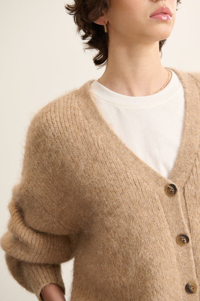 Gilet BISCOTTI, Garance Paris AH 2025, coloris beige, à la coupe ample, col V et bouton effet corne. 