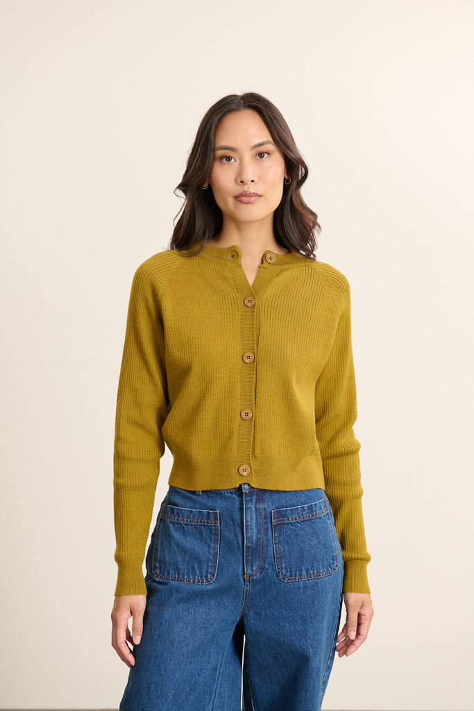 Gilet olive à emmanchures raglan, collection Garance Paris automne hiver 2025, fermeture bouton corne et col rond.