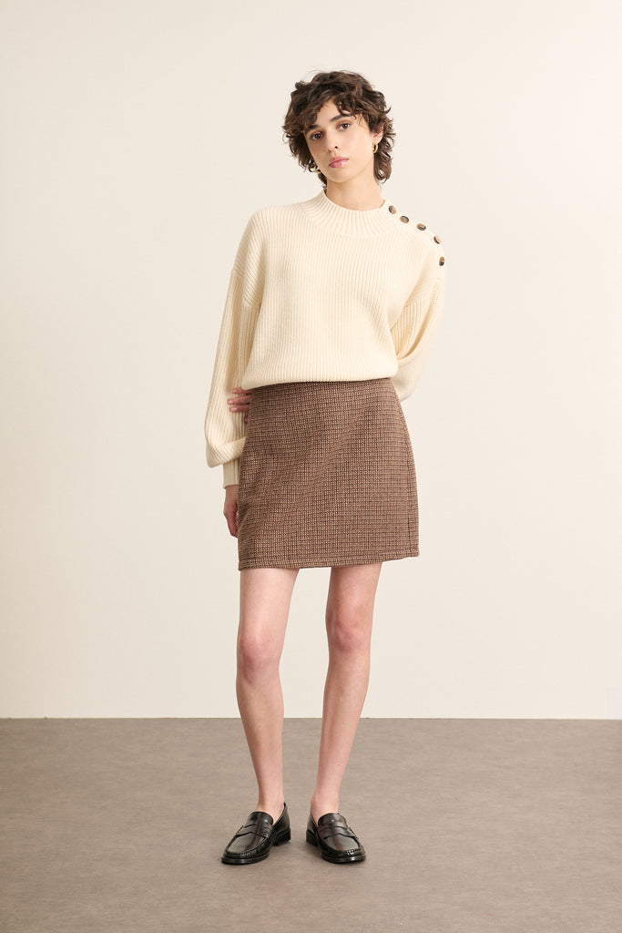 Mannequin femme de face portant une mini jupe marron à motif pied-de-poule, coupe droite au-dessus du genou.
