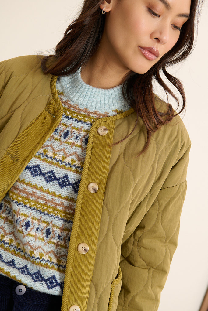 Manteau court réversible avec emmanchures souples et tombé naturel sur l'épaule, coloris kaki.