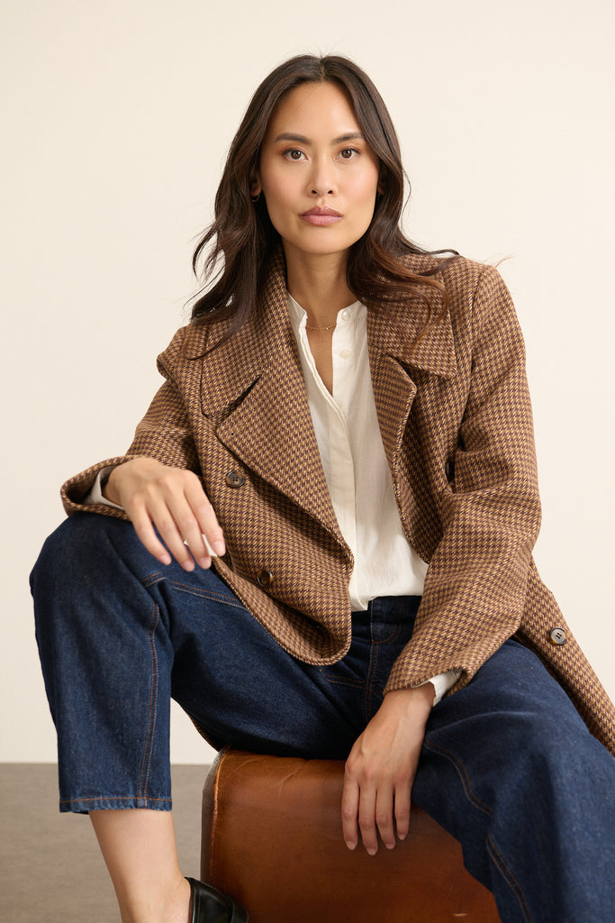 Porté fermé, le manteau affirme son style caban avec un double boutonnage visible et un volume bien équilibré.