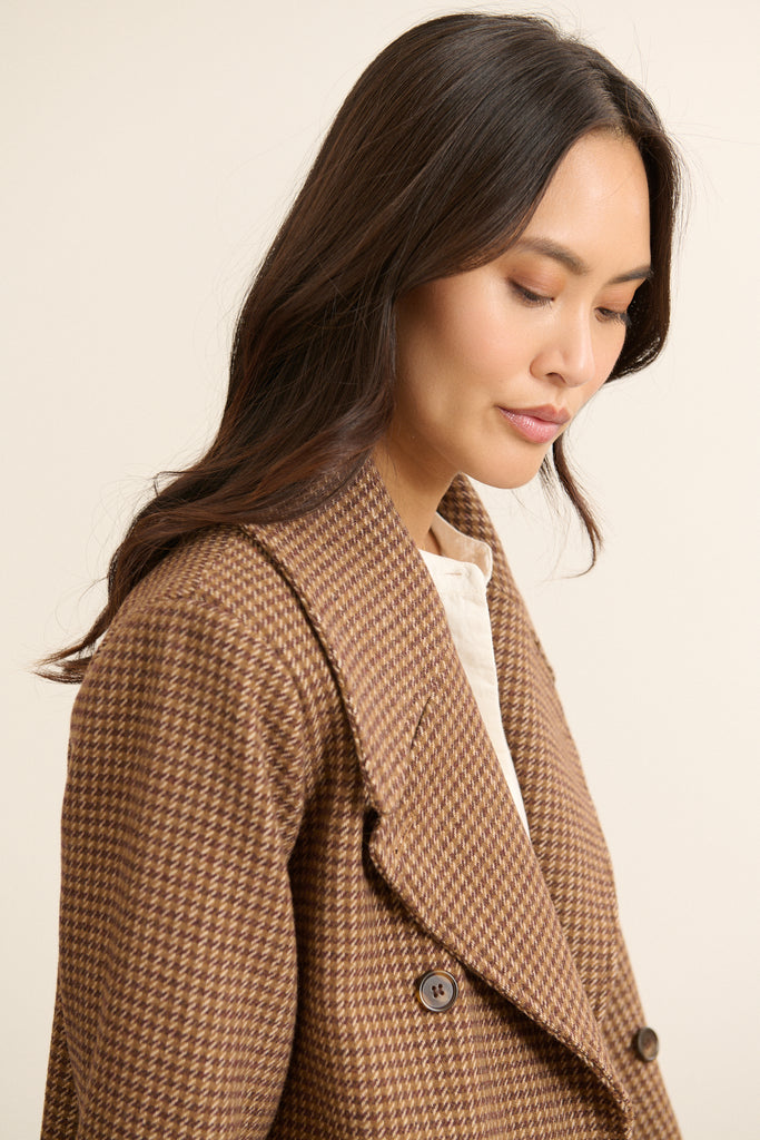 Manteau BRIDGET porté ouvert, coupe droite et courte, silhouette structurée dans un style citadin et moderne.