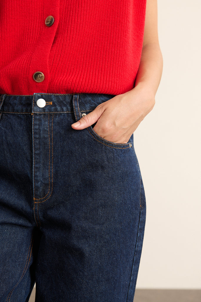 Pantalon en denim brut 100 % coton au tissage séré, coloris brut foncé uniforme avec surpiqûres contrastées visibles.