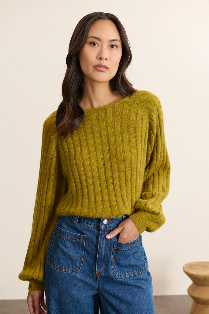 Femme portant le pantalon TORRES en denim coloris bleu à la coupe longue et droite, avec fermeture zippée et bouton.