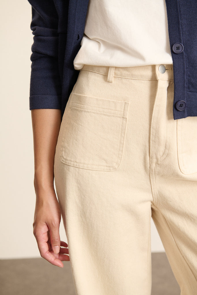 Denim écru au tissage sergé régulier, matière 100 % coton avec surpiqûres contrastées visibles sur l'ensemble du jean.