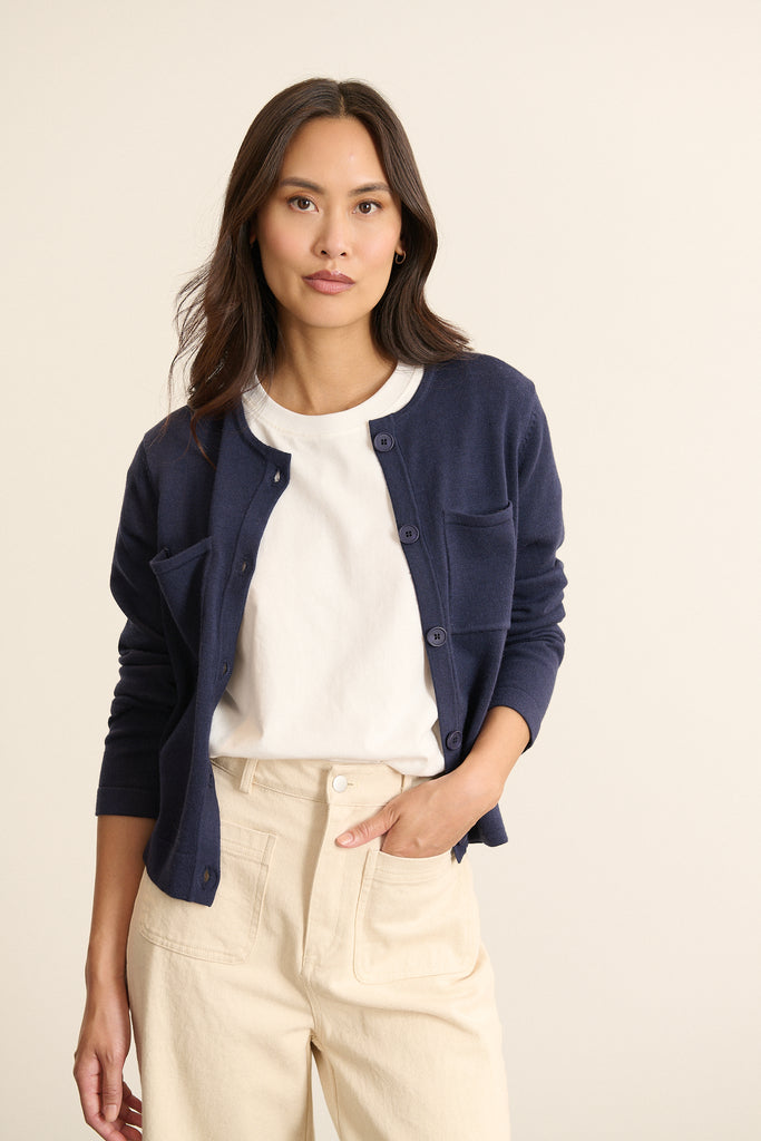 Femme portant le pantalon TORRES en denim coloris écru à la coupe longue et droite, avec fermeture zippée et bouton.