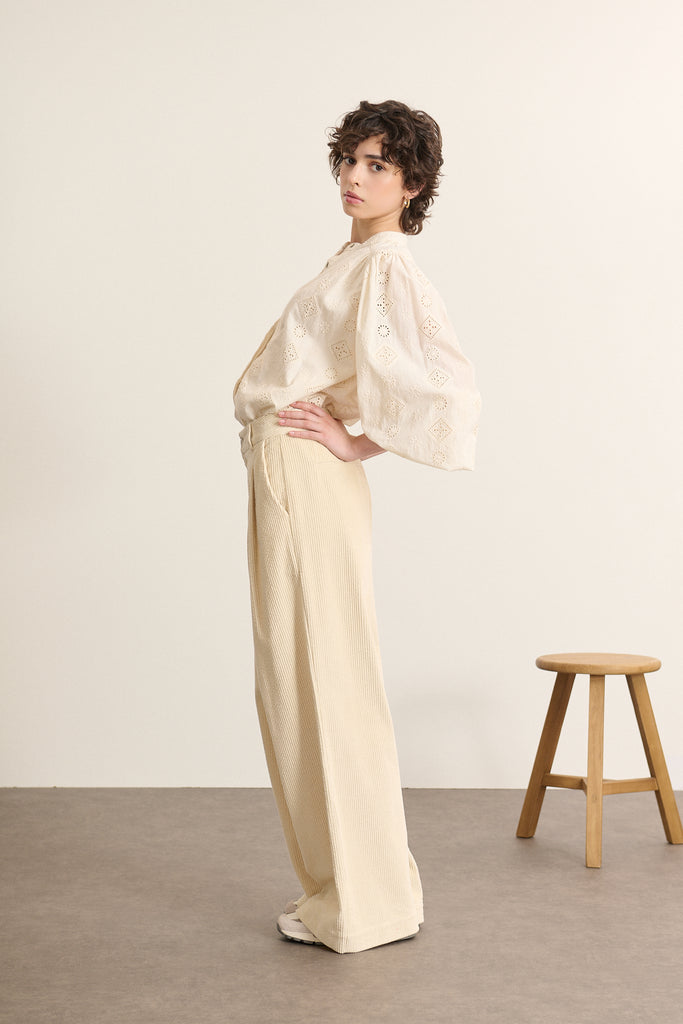 Bas pour femme à la coupe droite aux jambes larges, coloris écru, à pinces en velours et poches à l'avant.