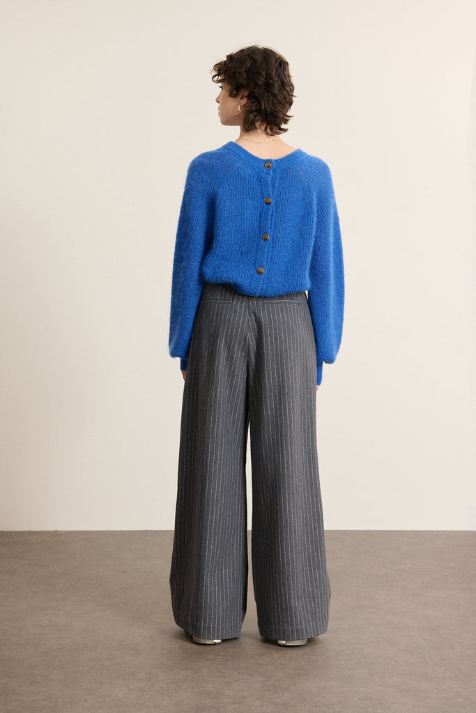 Pantalon pour femmes à pinces en laine, polyester et tencel, rayures fines tissées sur un fond de couleur gris.