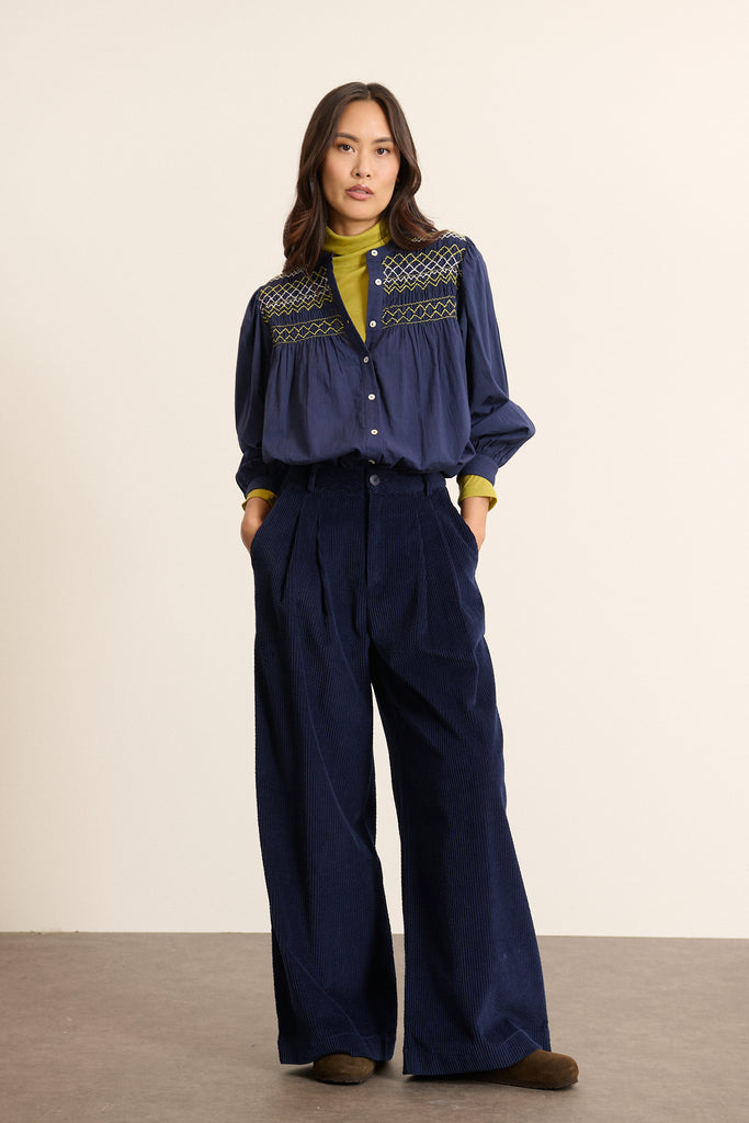 Pantalon à pinces en velours coloris marine, collection Garance Paris automne hiver 2025, jambes larges et poches devant.