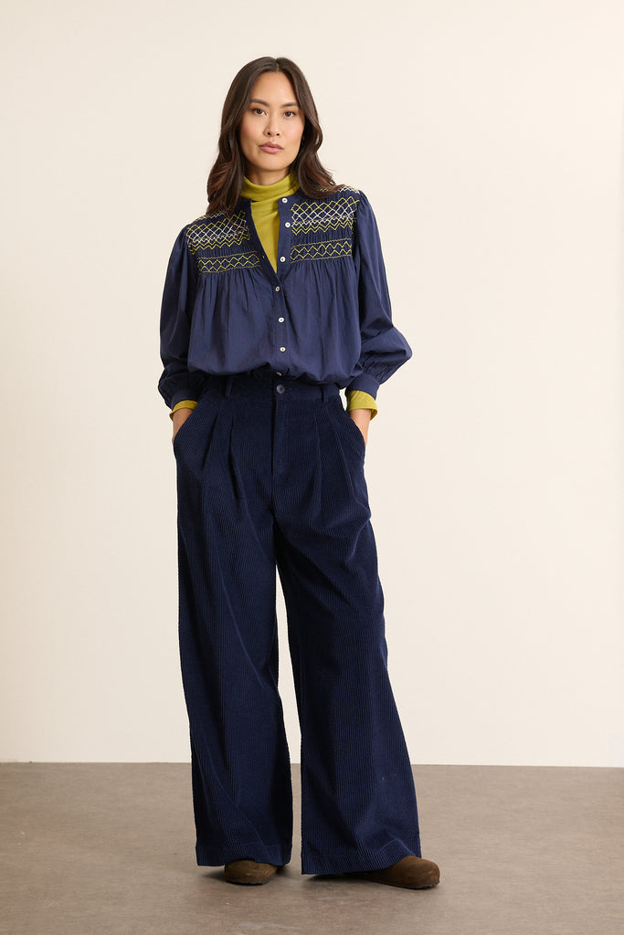 Mannequin femme de face portant en velours coloris marine, jambes larges, taille marquée et pinces apparentes. 