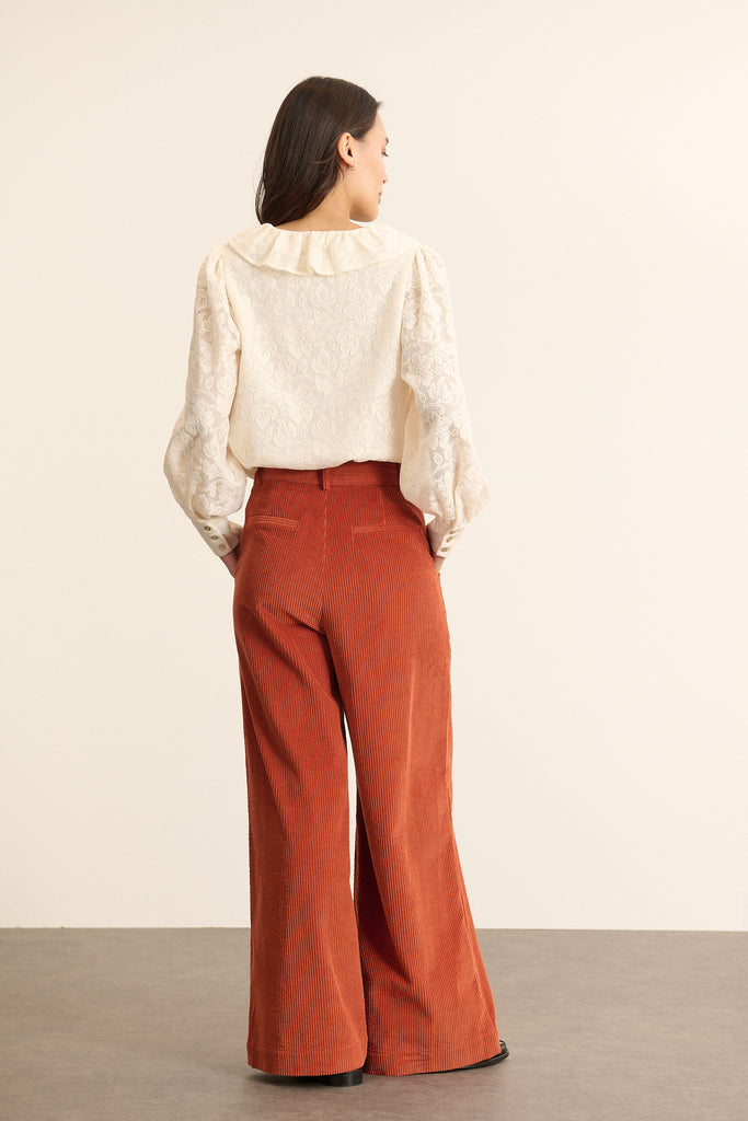 Pantalon à pinces en velours, coupe droite à jambes larges avec poches à l'avant et fermeture par zip et bouton. 
