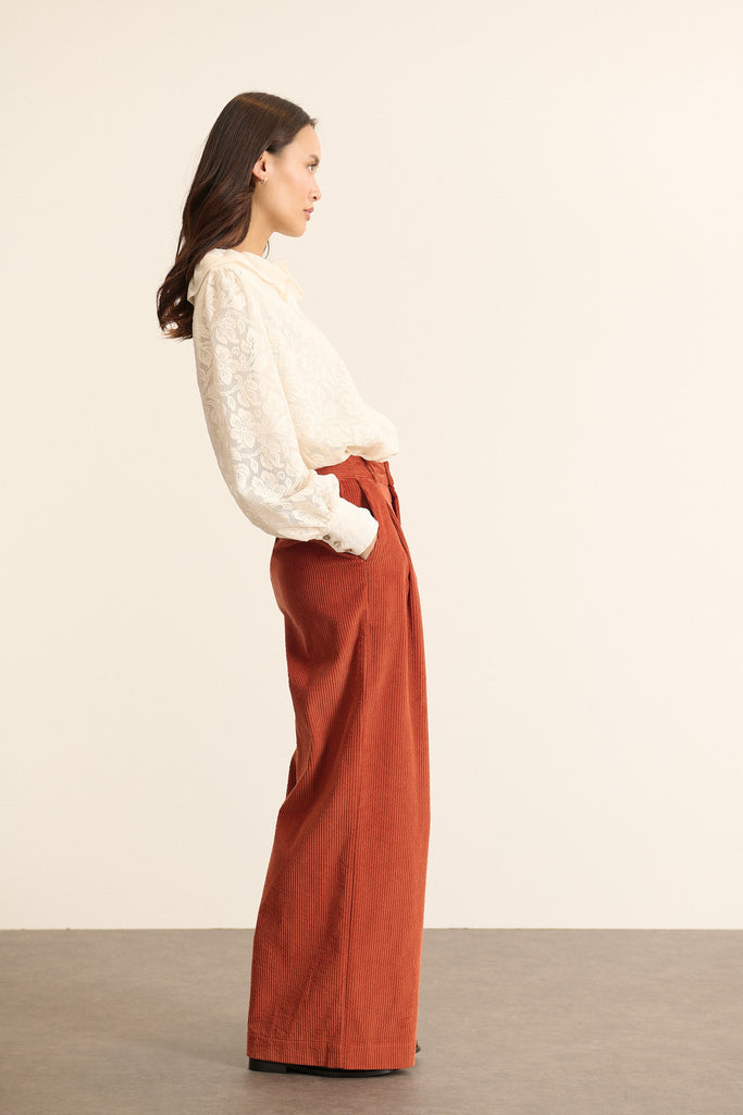Bas pour femme à la coupe droite aux jambes larges, coloris terre cuite, à pinces en velours et poches à l'avant.
