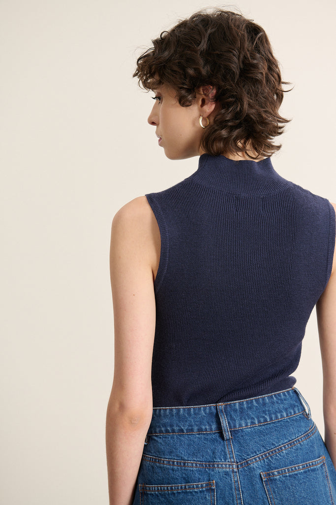 Vue arrière du pull sans manches, coupe près du corps avec couture latérale discrète et bord-côtes resserré.