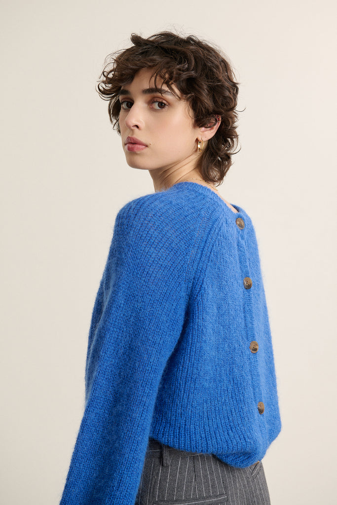 Boutonnage dans le dos avec petits boutons ton sur ton, possibilité de porter le pull dans les deux sens selon le style.