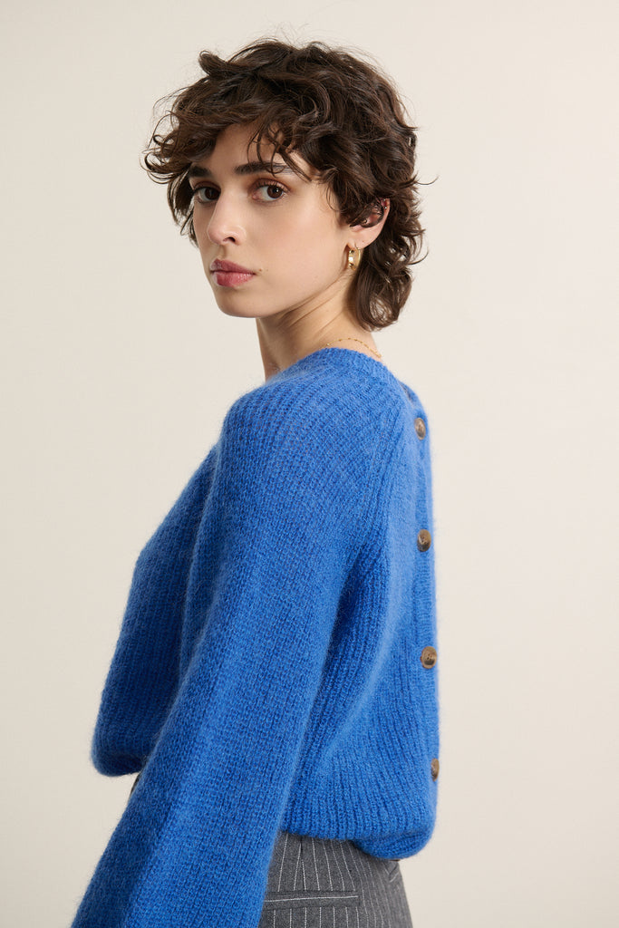 Pull coloris bleu électrique, à la coupe ample aux emmanchures raglan, avec boutonnage dans le dos, un essentiel chez Garance.
