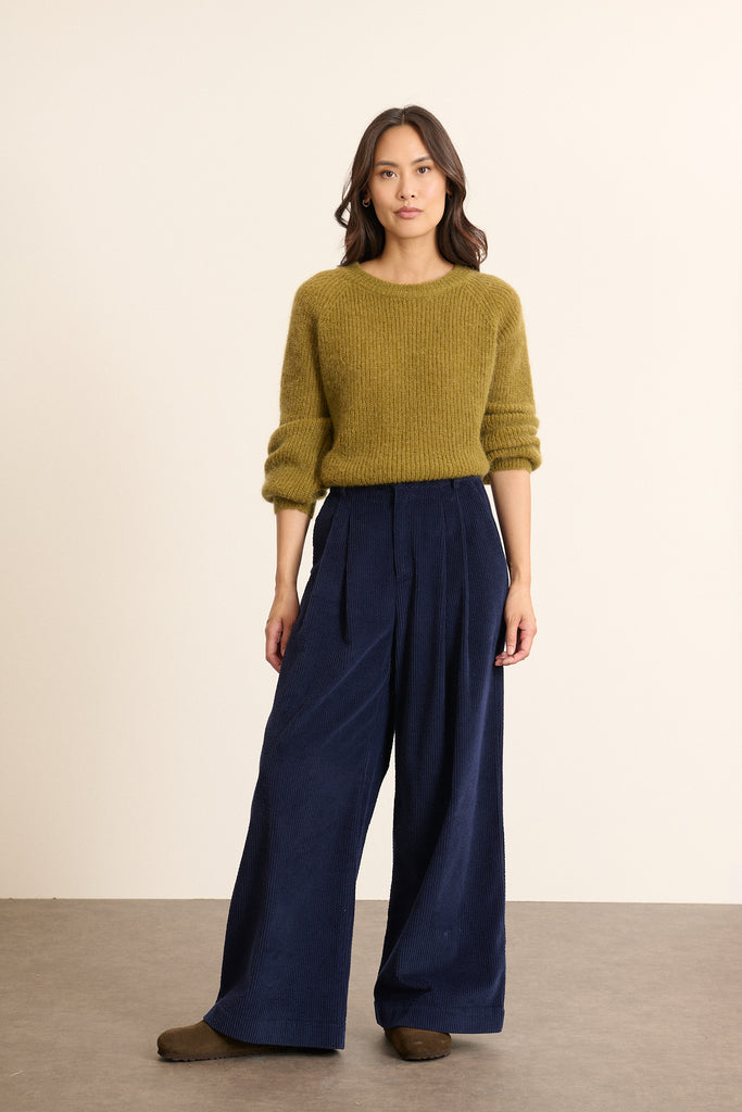 Pull coloris olive, à la coupe ample aux emmanchures raglan, avec boutonnage dans le dos, un essentiel chez Garance.