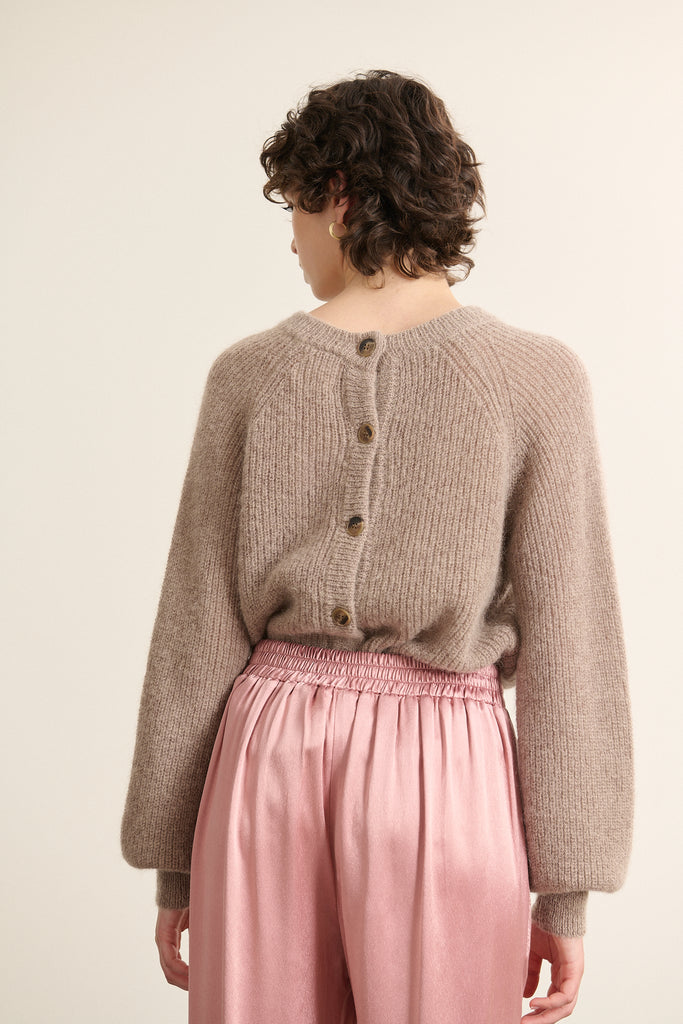 Boutonnage dans le dos avec petits boutons ton sur ton, possibilité de porter le pull dans les deux sens selon le style.