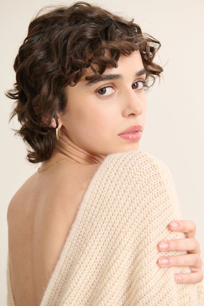 Maille douce composée de polyamide, angora, viscose et laine, texture duveteuse et chaude au toucher léger.