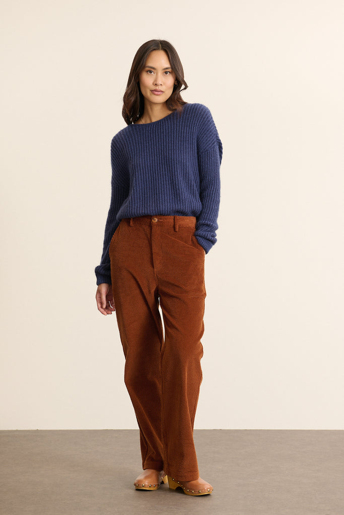Mannequin femme de face portant un pull marine à manches longues, coupe droite avec col rond devant et décolleté au dos.