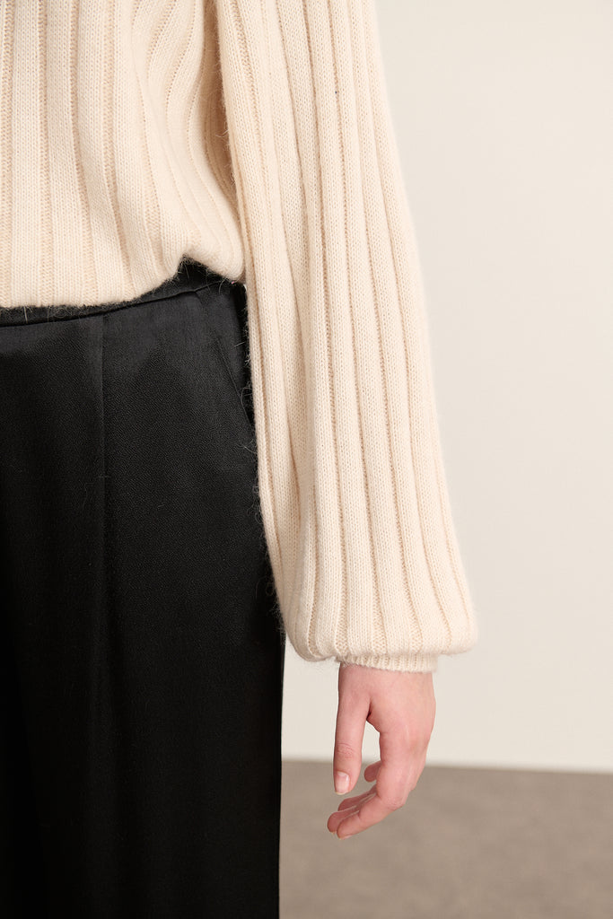 Pull avec emmanchures raglan soulignées par une couture en diagonale depuis le col jusqu’aux dessous de bras.