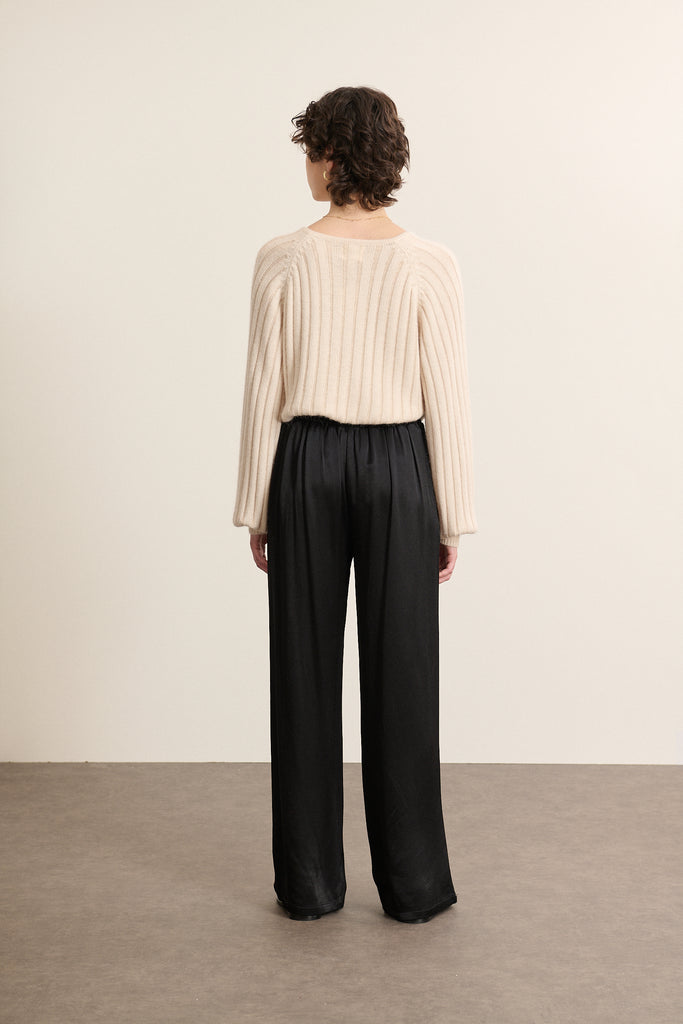 Vue arrière du pull beige en maille côtelée, coupe droite avec manches amples resserrées au poignet.