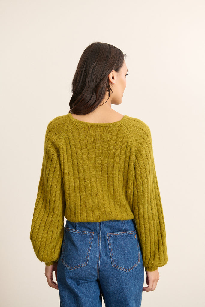 Vue arrière du pull olive en maille côtelée, coupe droite avec manches amples resserrées au poignet.