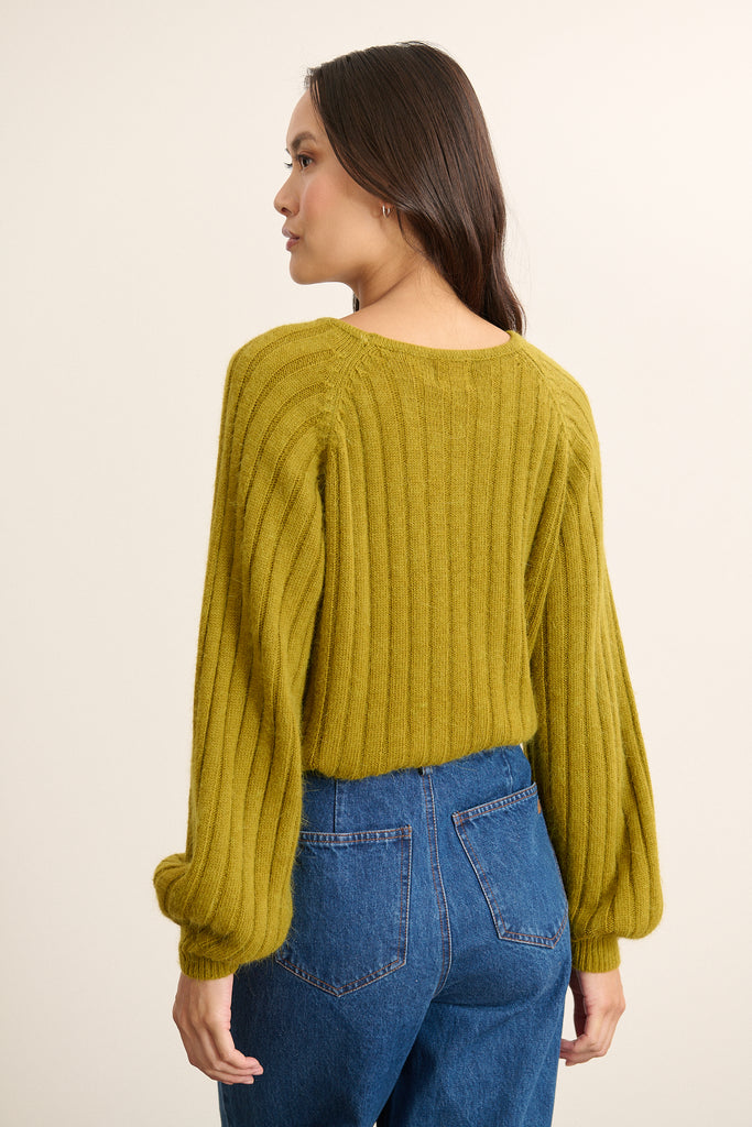 Pull avec emmanchures raglan soulignées par une couture en diagonale depuis le col jusqu’aux dessous de bras.