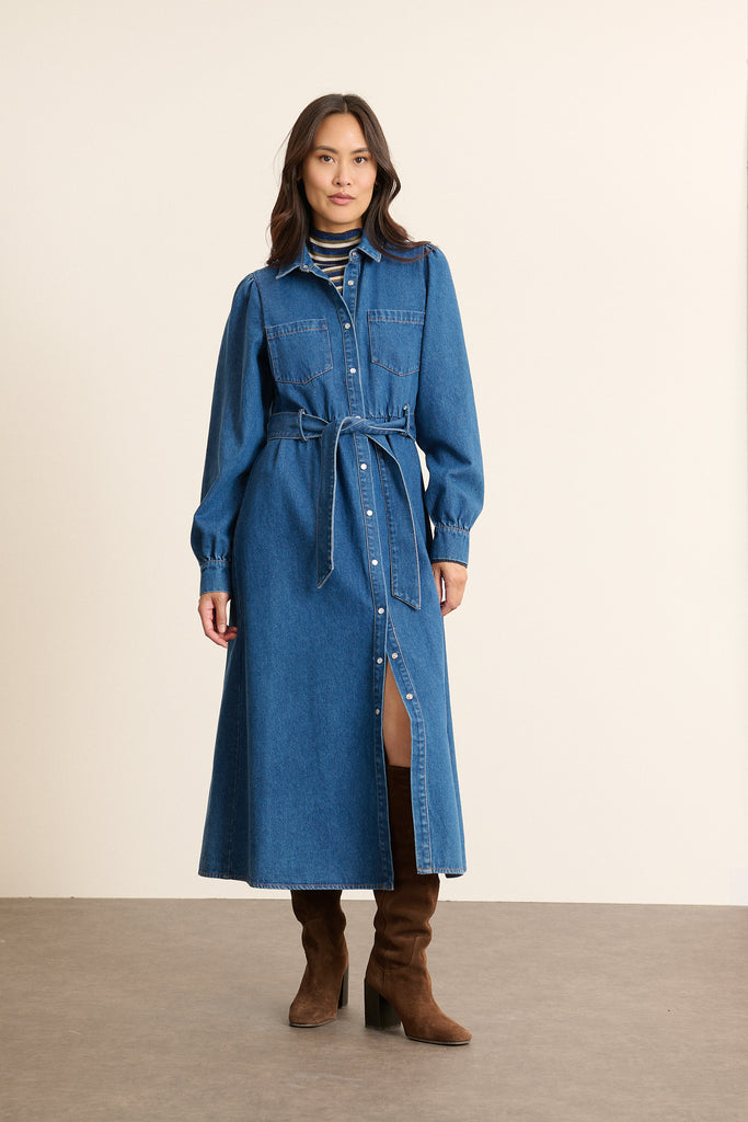 Mannequin femme de face portant une robe chemise midi en denim bleu, coupe droite ceinturée et poches poitrine.