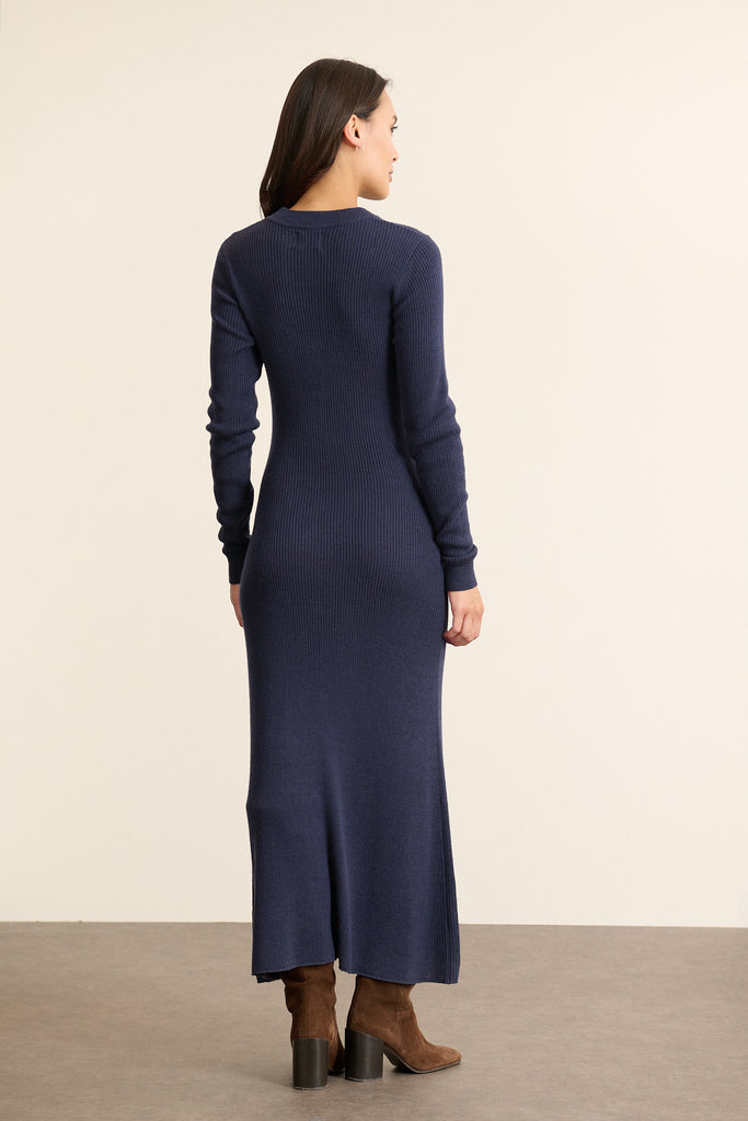Vue arrière de la robe en maille marine, taille marquée et jupe longue évasée, couture centrale discrète.