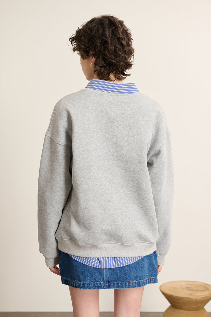 Vue arrière du sweat ample coloris gris, coupe droite avec base et poignets en bord-côtes élastiqué ton sur ton.