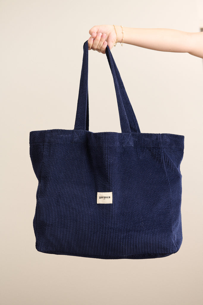 Sac SOLSTICE en velours 100 % coton coloris marine, format rectangulaire souple avec anses larges en ton sur ton.