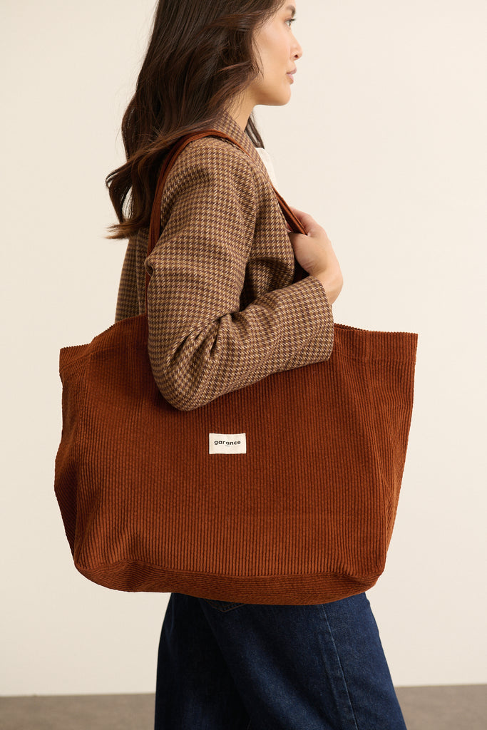 Anses larges fixées en haut du sac par surpiqûres renforcées, longueur adaptée pour un porté épaule confortable.