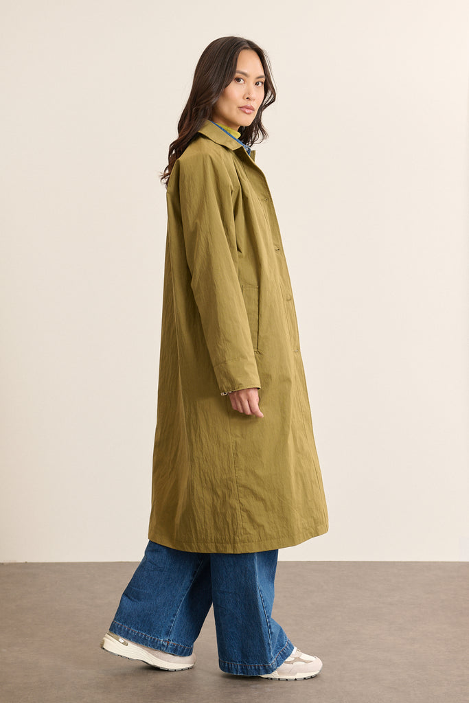 Profil du trench longueur maxi VANCOUVER coloris kaki avec une emmanchure tombante au dos et une doublure à carreaux.