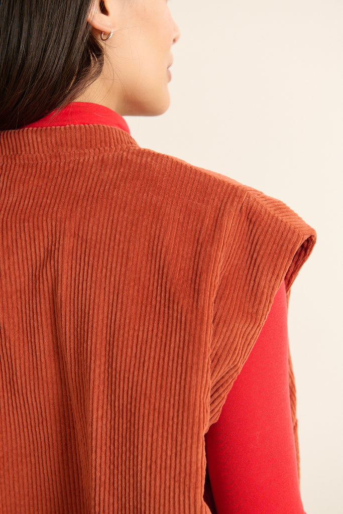 Veste sans manches matelassée en velours terre cuite, collection Garance Paris automne hivers 2025, avec bouton effet corne.