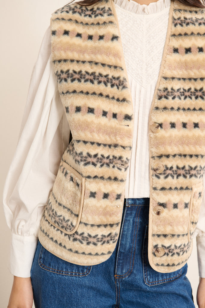 Veste sans manches fabriquée entièrement en polyester coloris beige avec poches  à l'avant et bouton effet corne.