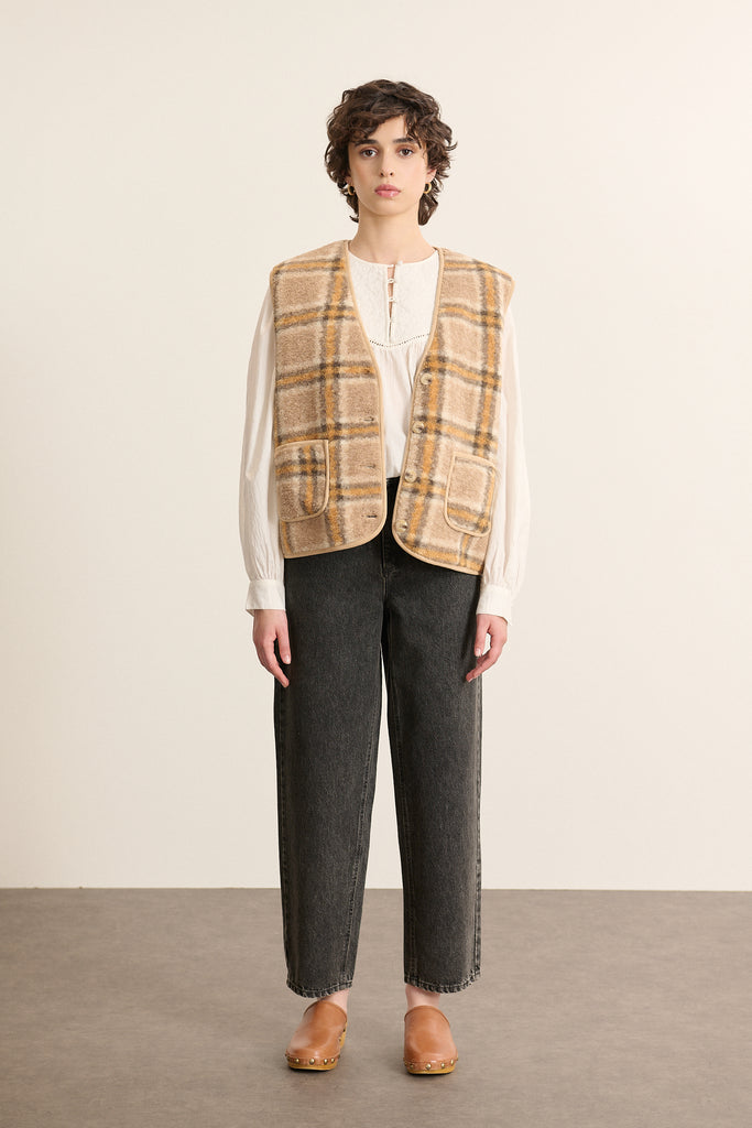 Mannequin femme de face portant une veste sans manches imprimée jaune, coupe droite avec col rond et poches plaquées.