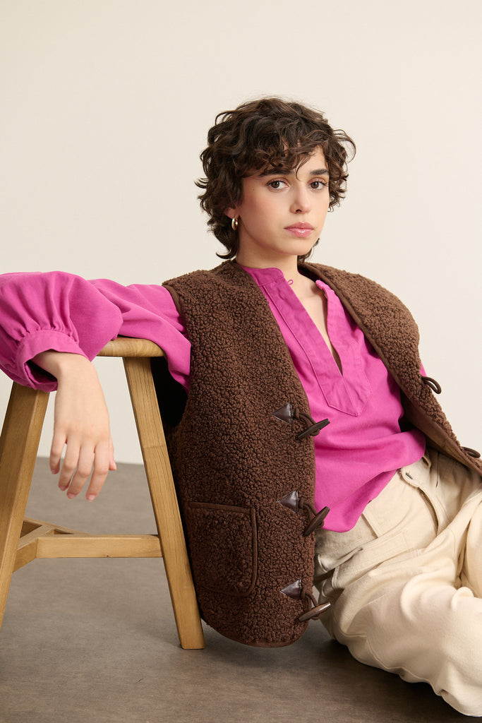 Veste sans manches marron effet peau de mouton, collection Garance automne hiver 2025, fermeture brandebourg sur le devant.