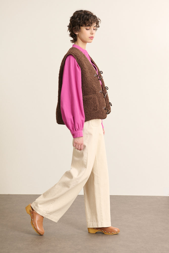 Fabriquée entièrement en polyester, veste sans manches POLETTE coloris marron avec bouton brandebourg.