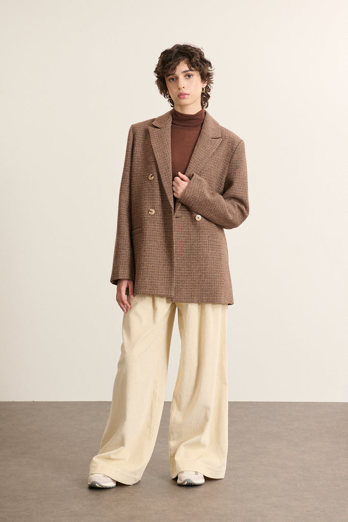 Veste Garance Pairs AH 2025, tailleur croisé avec tissu esprit pied de poule, bouton effet corne et double boutonnage.